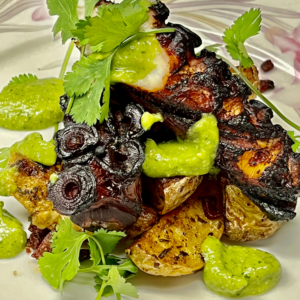 Grilled Octopus with cilantro on top of a bed of roasted potatoes